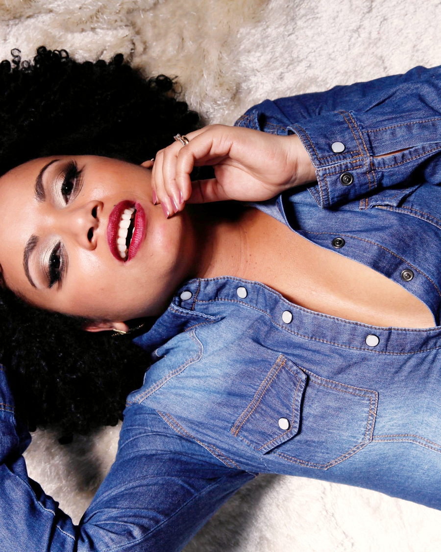 A woman lying down with her hand in her afro