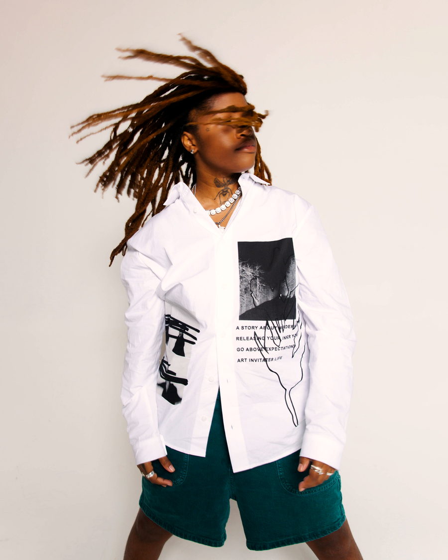 A person with locs mid-movement, hair swinging