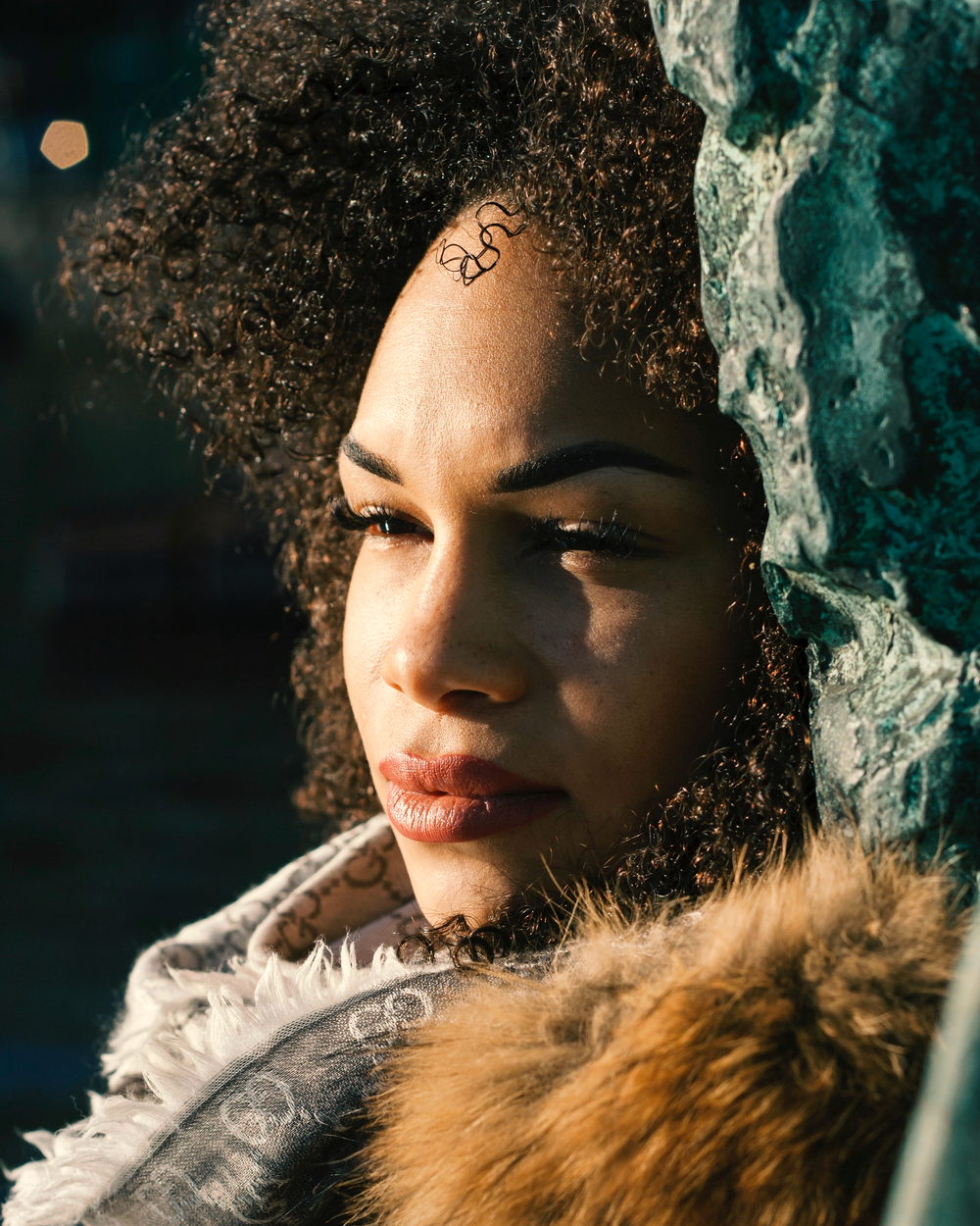 A woman with defined curls looking into the light