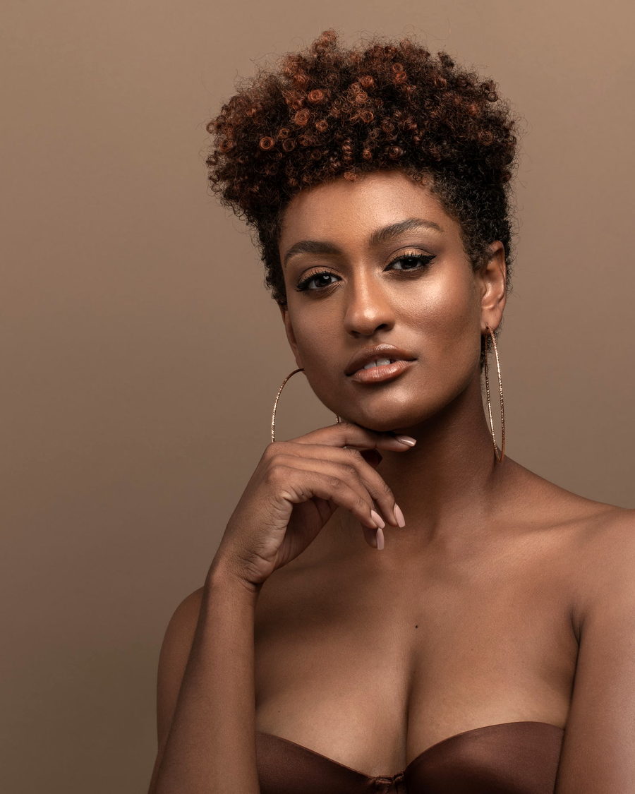 A studio portrait of a woman with soft, defined coils